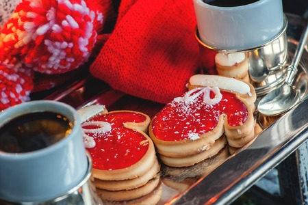 Two of the pie dough mittens and marmalade with black coffee on a cozy Christmas table. Close-up. The horizontal frame.の写真素材
