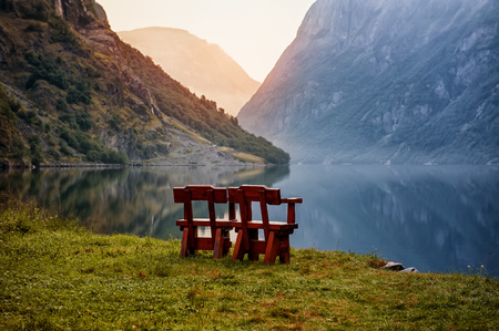 Beautiful choice for unity with nature on the banks of the Norwegian fjord Two chairs to relax in the mountains. Sunrise . The horizontal frame.の写真素材