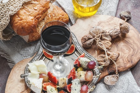 A glass of dry red wine and Italian Focaccia bread with cheese and olive oil and sun dried tomatoes. Selective focus. The horizontal frame.の写真素材
