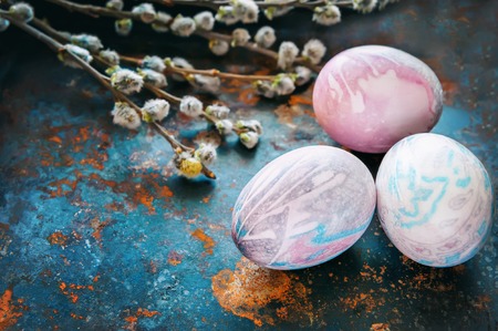 Colorful Easter eggs lying on a beautiful vintage background with bouquet made of willow branches. The view from the top. The Easter brunch. Copy space.の写真素材
