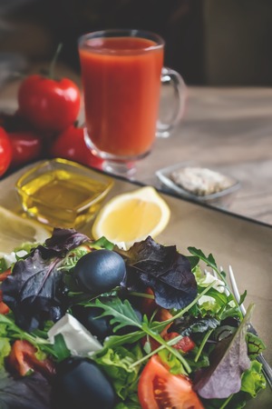 Salad diet for weight correction from the leaves of Lollo Rosso lettuce, watercress salad and other green herbs with tomatoes, olives and fitaki. Close up.の写真素材