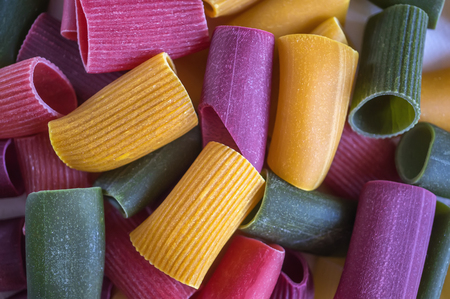 Mixed selection of dried pasta on wooden background. Macaroni scattered on a glass jar. Background. Close up.の写真素材