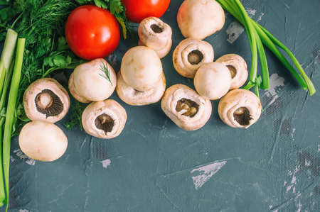 Fresh mushrooms and vegetables with herbs. Wooden background, close-up. Copy spase.の写真素材
