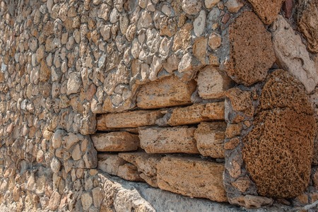 Background of natural multi-colored stone on a plain textured wall with cracks close upの写真素材