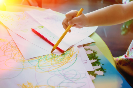Close-up of a small child draws colored pencilsの写真素材