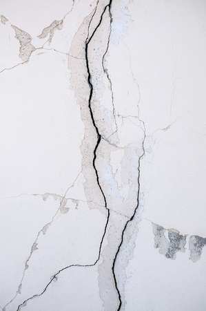 Original background of natural cement plaster on the wall of gray plain with the texture of cracks and bricks .の写真素材