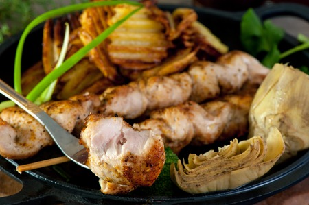 chicken kebab, fresh cucumbers, artichokes and peppers on a white ceramic pan. Horizontal frame.の写真素材