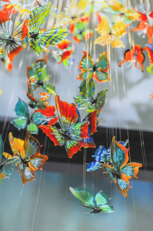 Glass colorful butterflies hang in the shop window.の写真素材