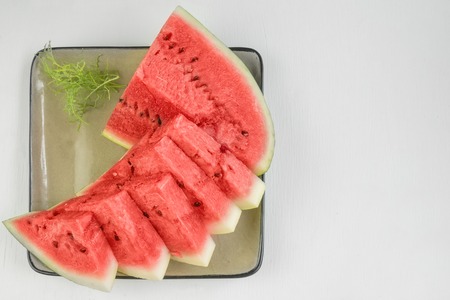 Triangular pieces of red ripe watermelon on a plate. Close up.の写真素材