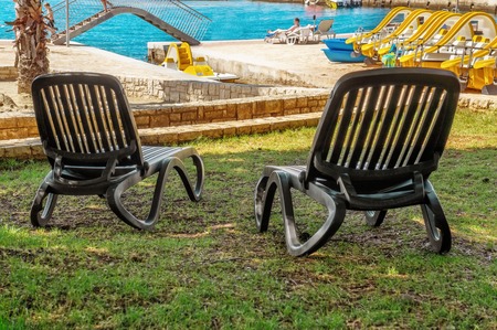 Two black empty sun loungers on a beautiful European beachの写真素材