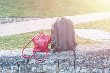 Two hipster backpacks red and black are on the side of the road.の写真素材