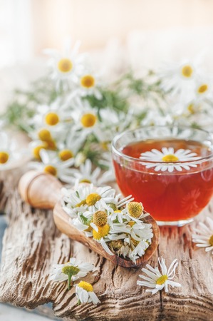 A clear Cup of medicinal chamomile tea on an old wooden table. Health and healthy lifestyle concept.の写真素材