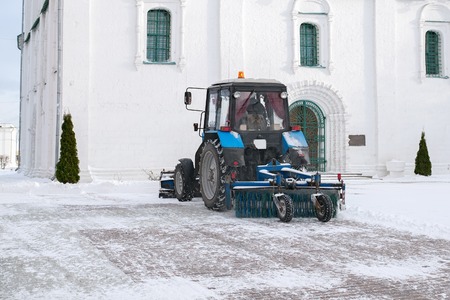 Blue bulldozer cleans the streets after a heavy natural snowfall. Getting ready for Christmas. Sunny frosty day.の写真素材