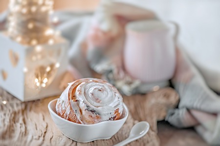 Delicious homemade sweet buns with cinnamon and icing sugar Christmas at the old wooden table. Traditional Swedish pastries, kanelbullarの写真素材