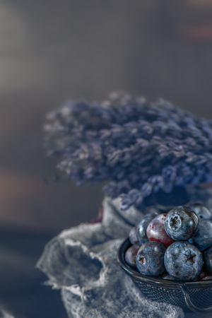 Blue berries blueberries in wicker white basket with autumn leaves in a rustic style. Close-up. Copy space.の写真素材