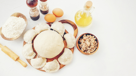 The process of making homemade raw dough dumplings with meat filling on a wooden board. Ukrainian dumplings. A traditional dish. Selective focusの写真素材