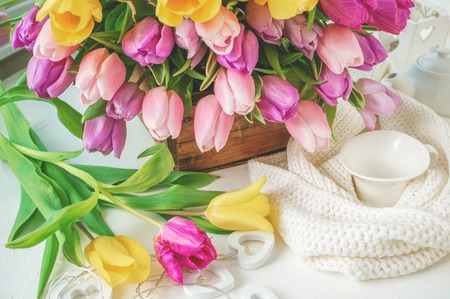 A beautiful bouquet of tulips with a white cup for tea. Close up