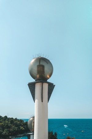 Round glass lanterns on the background of the sea coast. Shoreline lighting with energy-saving lamps.の写真素材