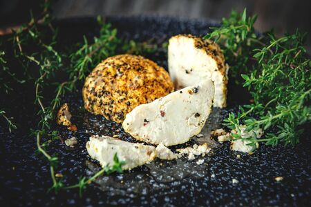 Delicacy round cheese Belper knoll with vegetables and aromatic herbs on a wooden table. Fresh farm products in Russia.の写真素材