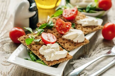 Burato cheese and salad on diet bread. Lollo Rosso lettuce, cress salad and other green herbs. The concept of a healthy diet for the weight loss . Italian dish. Selective focus.の写真素材