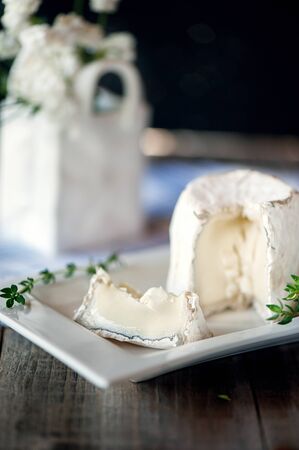 Traditional French goat milk cheese Saint-Maure-de-Touraine on a piece of delicate farm bread with...