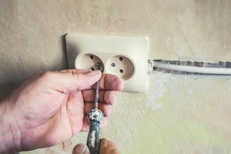Repair of electrical outlets in the wall of the house.Old broken light switch with power connection...