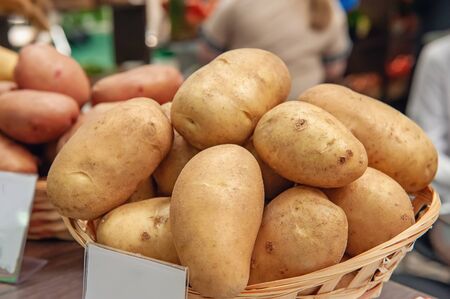 New potatoes are in a basket on the counter of the farmers ' market. The latest hybrid varieties of potatoes.の写真素材