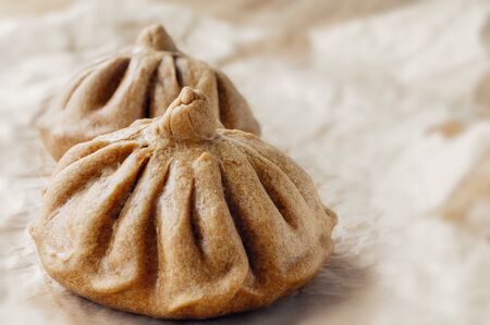Buns of rye flour are on light paper. Homemade cake. Mexican day of dead bread, pan de Muerto.