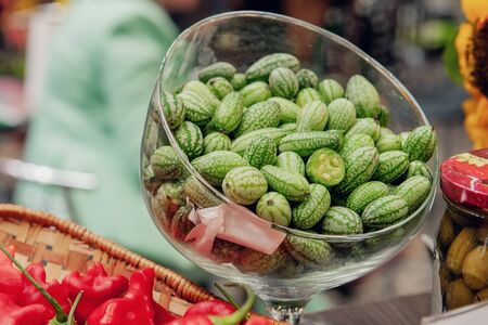 Green fruit vegetable melodii in a glass bowl. Ripe melothria is on the table.の写真素材