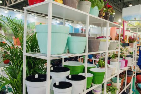 Ceramic multi-colored pots and vases for flowers on white shelves in the market.の写真素材