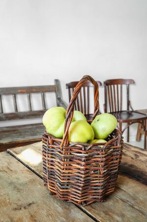 Green apples in an old crafting basket on an old wooden table are ready for processing. Copy space.の写真素材