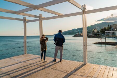 Yalta, Crimea, Massandrovsky beach October 6, 2018: Lovers admire the beautiful view of the mountains and the sea. Tourists are photographed on the pier against the seaのeditorial素材