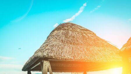 Beach scene on a Sunny bright day. Thatched roof over the Seating area.の写真素材