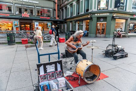 Oslo, Norway-August 1, 2013: a street musician performs on the main street of Karl Johans gate. An...