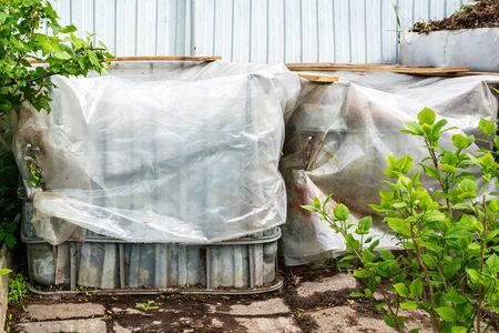 Plastic containers are reused for composting waste in the garden. fresh composted earth from the compost bin. Cover the compost from rain and waterlogging.の写真素材