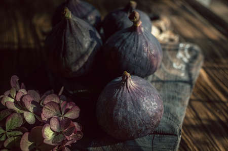 Still life fruits of ripe purple figs lying on a wooden table, close-upの写真素材