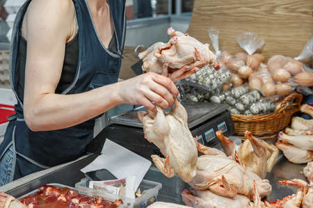 seller keeps fresh home-made chicken carcass on the counter of the meat pavilion, raw chicken carcasses are sold on the counter of the market. Selective focus.の写真素材