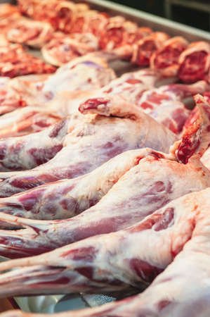 hind leg of the sheep is prepared for sale. Showcase of a butcher's shop with meat lamb.の写真素材