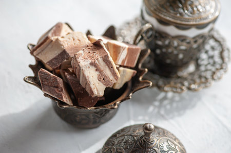 Pieces of chocolate Oriental halva with coffee in a Cup. Eastern tea party.