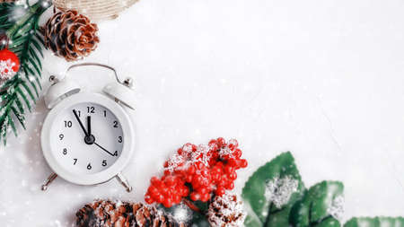 Christmas clock on a wooden wall with a Christmas tree and cones. Top view, copy space.の写真素材