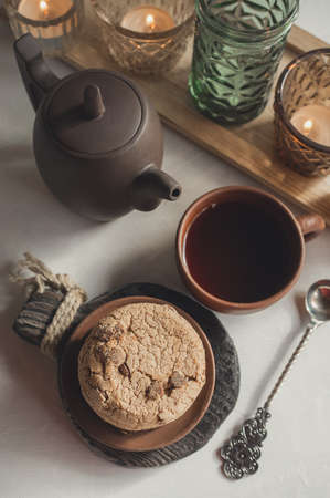 Almond and chocolate homemade cookies on the table with a ceramic Cup of tea and a kettle. top view.の写真素材