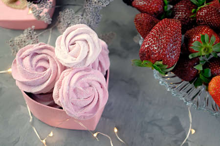 fresh handmade marshmallows in a light mood. Close-up of a pink marshmallow in a pink heart-shaped...