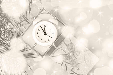 Christmas gift boxes on a light background with a white clock and a sprig of spruce. Top view, copy...