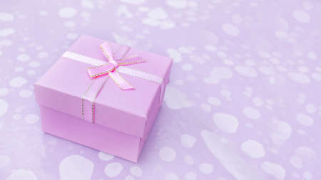 Christmas gift box on a pink background with a Christmas tree branch. Copy space.の写真素材