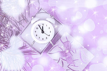 Christmas gift boxes on a light background with a white clock and a sprig of spruce. Top view, copy...