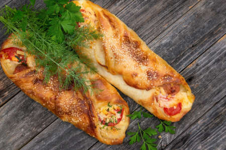 Baked sausage in dough with tomatoes, cheese and herbs mini pizza with sauce and sausage. Homemade cakes, handmade snacksの写真素材