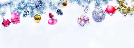 Holiday banner green Christmas tree with red and blue gifts on a light wooden background. Background happy New year greeting card Christmas Winter theme copy space for text. Snowfall. The horizontal frame.の写真素材