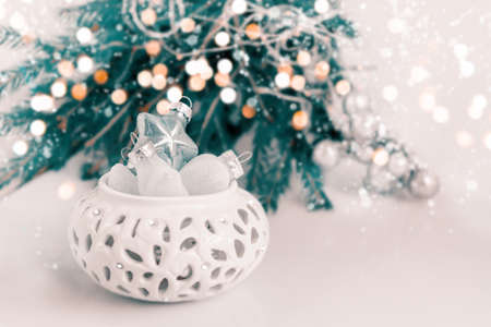 Christmas decorations are ready to dress up the Christmas tree. Christmas decor with toys, garlands and fir branches. Bokeh and glare. Selective soft focus.の写真素材