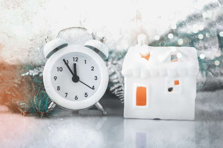 Toy white house and alarm clock - symbols of Christmas at home. Christmas picture, monochrome.の写真素材
