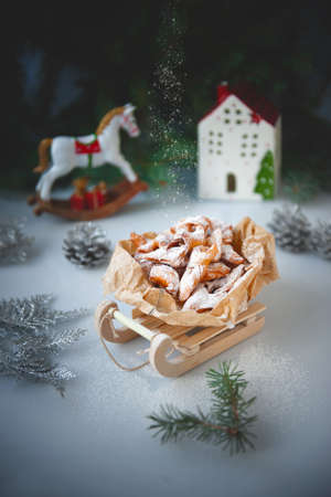 Firewood with sugar. Crunchy Cookies in the shape of icicles on a toy sled in a Christmas...